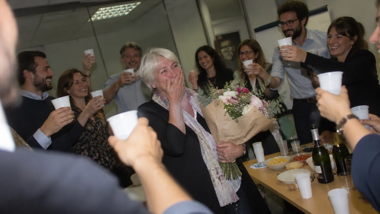 Colleagues raise their glasses to a colleague who is retiring